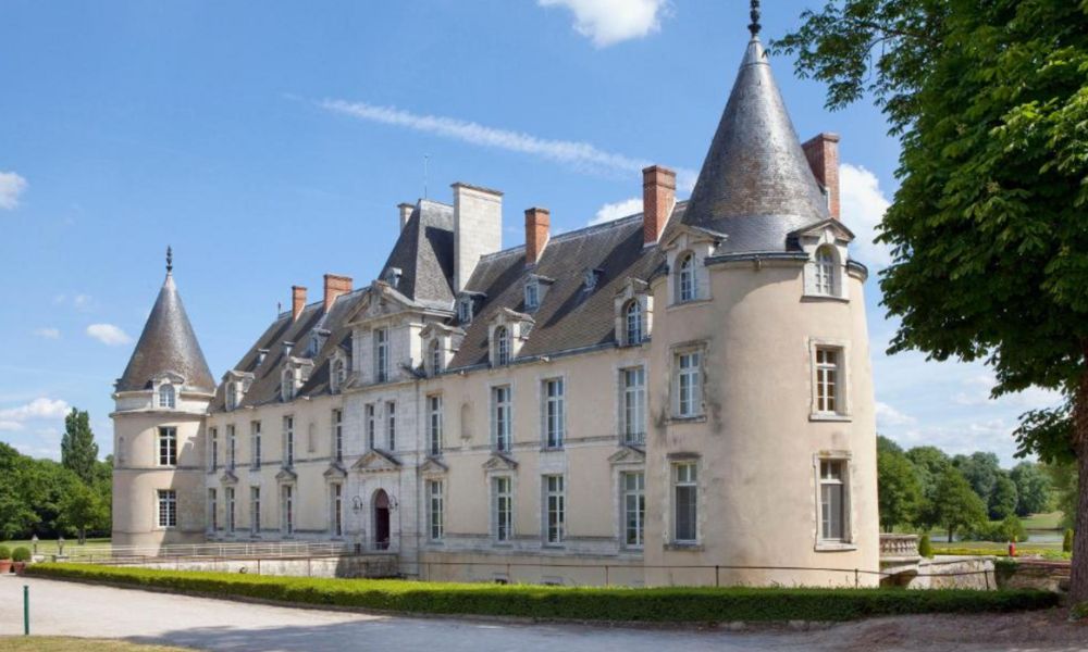 This is an image of a castle with two pointed peaks and a gravel path surrounding it.