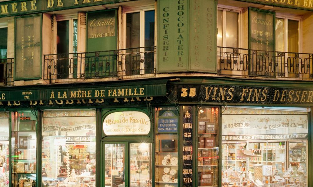 This is a photo of a cool gift store with green branding all around the building and bright lights casting over the wares.