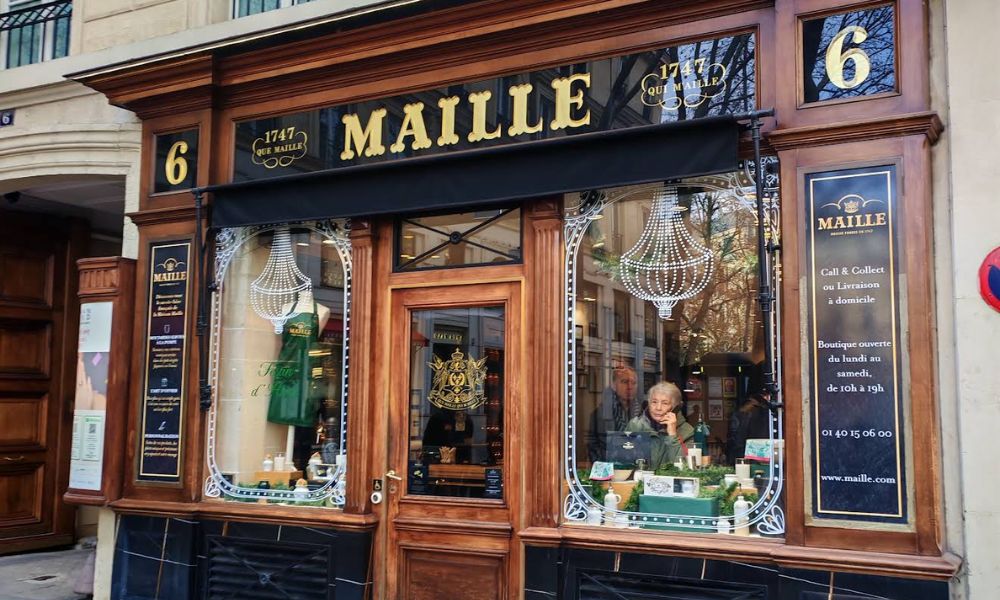 This is an image of the outside of the Maille shop where you can see some of their famous mustards and products in the window.