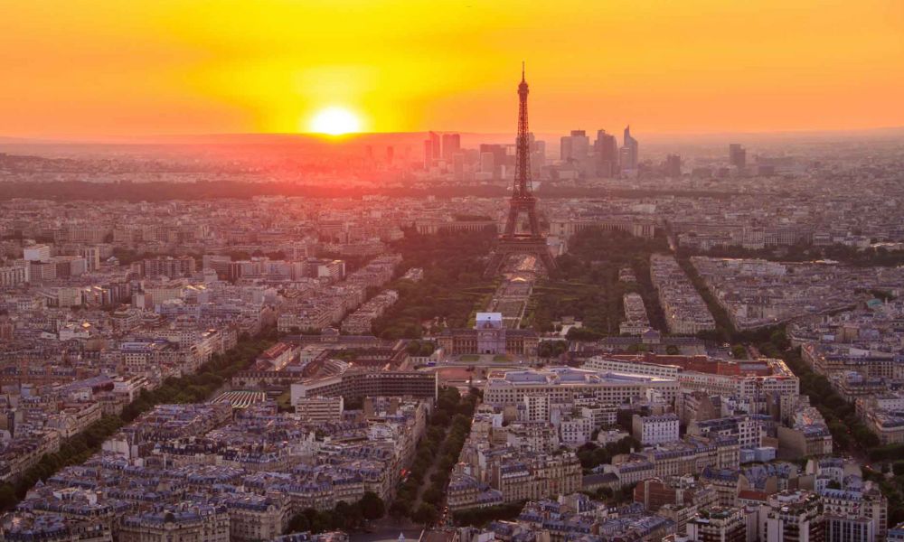 This is an image of Paris from a view at sunset, so the sky is orange and you can see the sun going down. You also have a really good view of Trocadero.