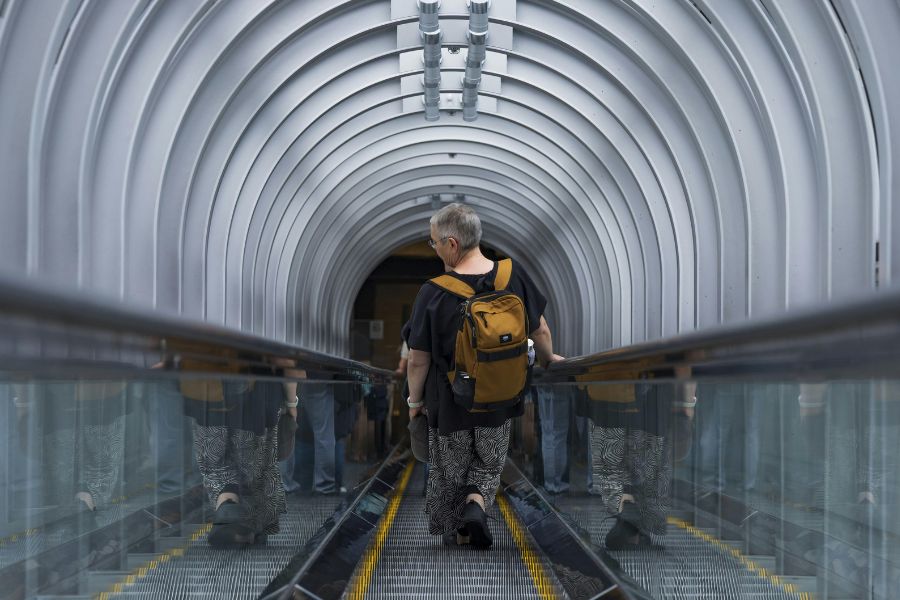 This is an image of a man standing in the middle of the escalator.