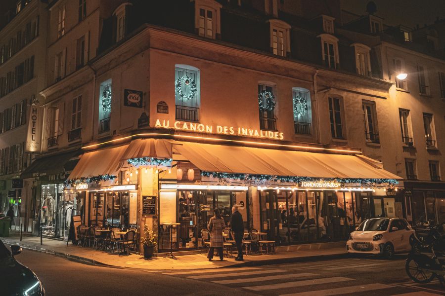 This is an image of a packed-out restaurant with people walking around outside and sitting on the veranda outside.