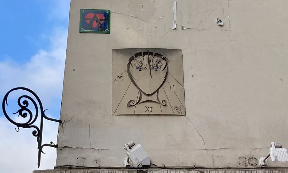 This is an image of a cool sundial style painting on a Parisian wall.