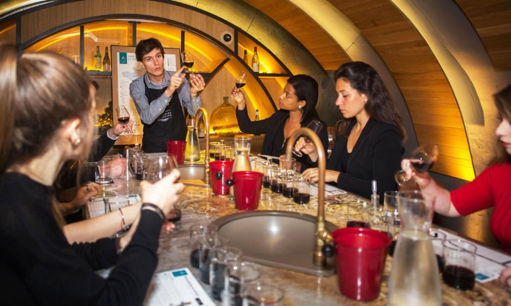 This is an image of a man showing a group of people how to make their own wine.