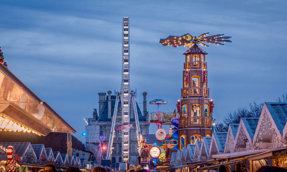 This is an image of a Christmas Market with plenty of stalls and rides in the back.