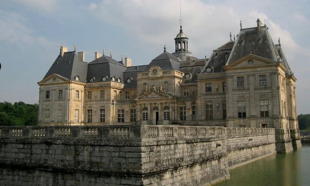 This is an image of a big castle with a lake around it.