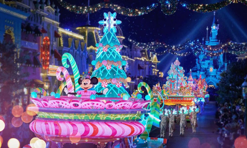This is an image of a Disneyland Paris march with plenty of Christmas lights and Mickey Mouse characters on floats walking down the main street.