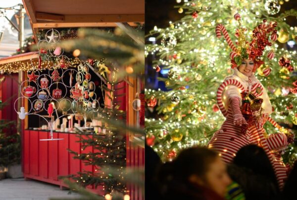 This is an image of a Christmas stall with with loads of ornaments for sale. To the right is a lady on stilts in front of a Christmas tree.
