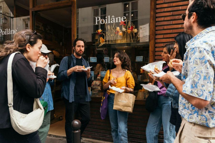 This is an image of a tour group eating in front of a bakery.