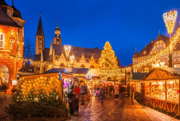 This is an image of a big Christmas market that is fully lit up with chalets full of food and Christmas market bits.