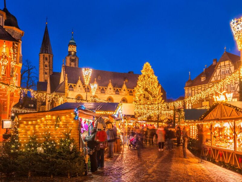 This is an image of a big Christmas market that is fully lit up with chalets full of food and Christmas market bits.