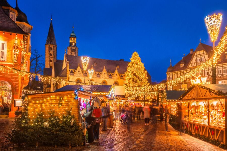 This is an image of a big Christmas market that is fully lit up with chalets full of food and Christmas market bits.