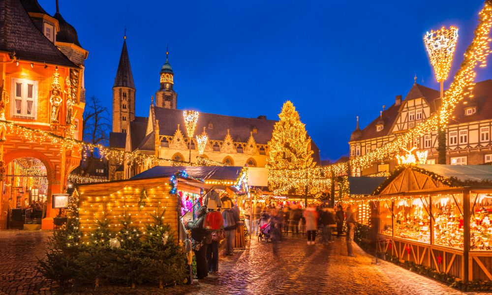 This is an image of a big Christmas market that is fully lit up with chalets full of food and Christmas market bits.