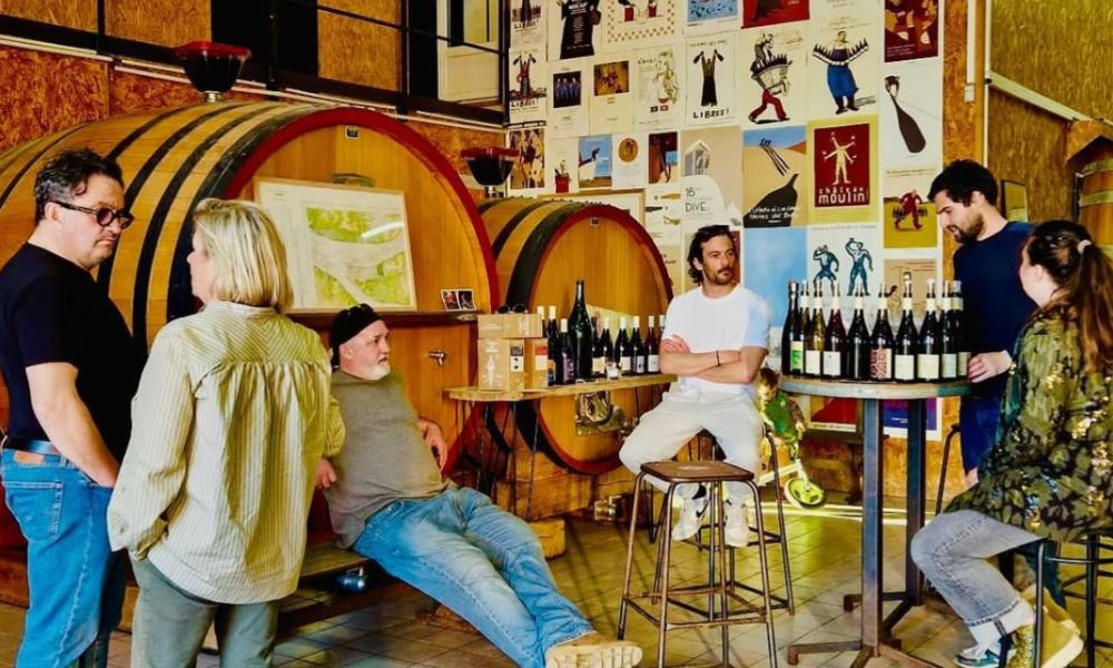 This is an image of a wine bar with people sitting at high bar tables.