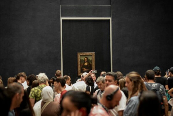 This is an image of everyone crowding around the Mona Lisa and taking pictures / looking at audio guides.