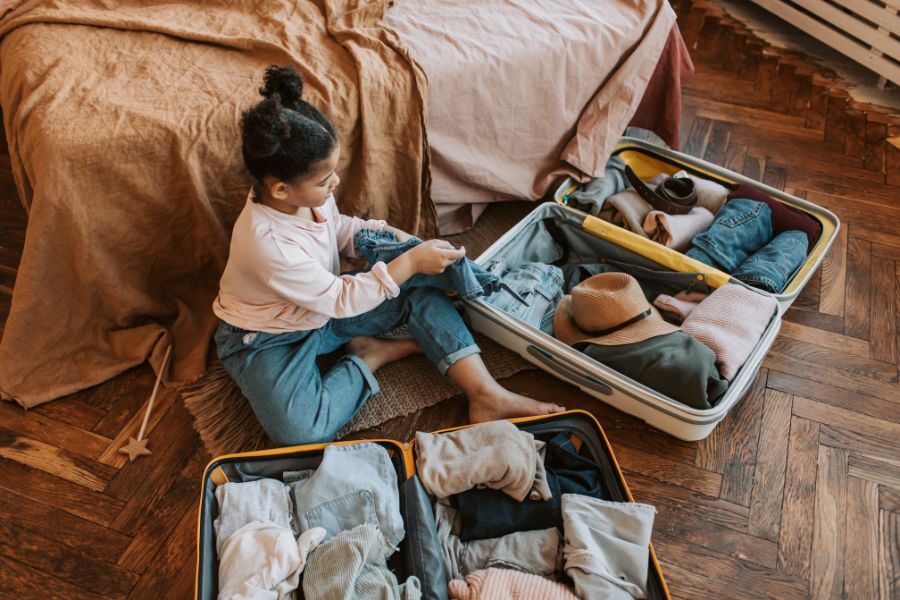 This is an image of a girl with a bunch of packed suitcases