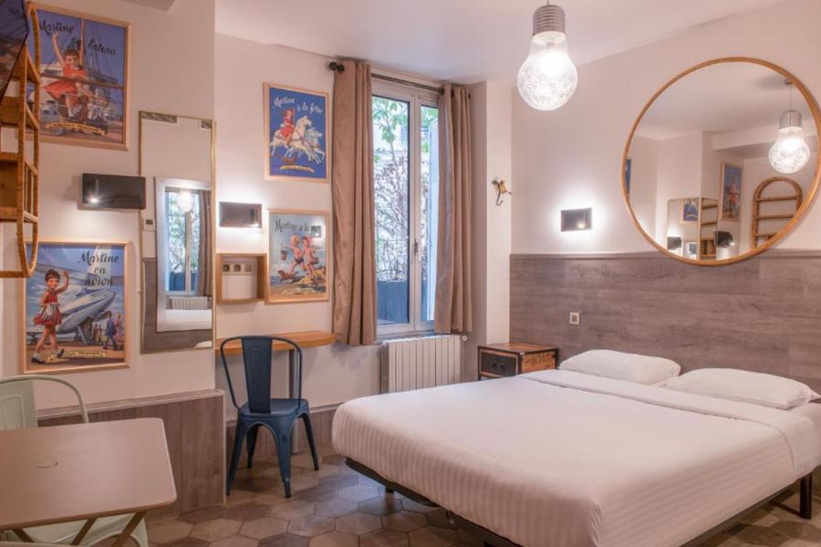 This is an image of a funky hotel room with a double bed and a lot of art frames hung on the wall.