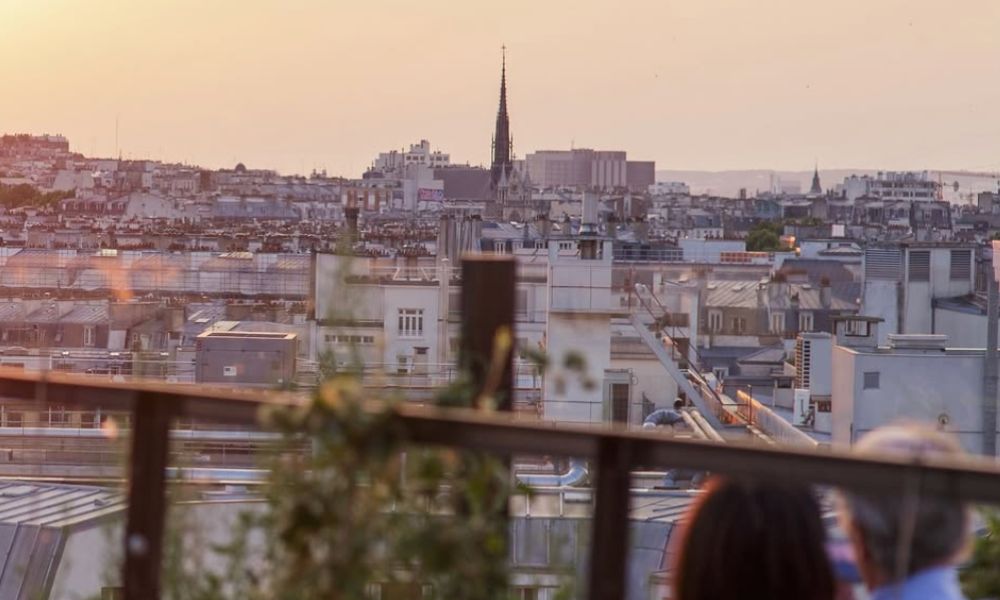 This is an image of a rooftop bar in Paris which has an amazing view of Montmartre and Paris's beautiful cobblestone district.