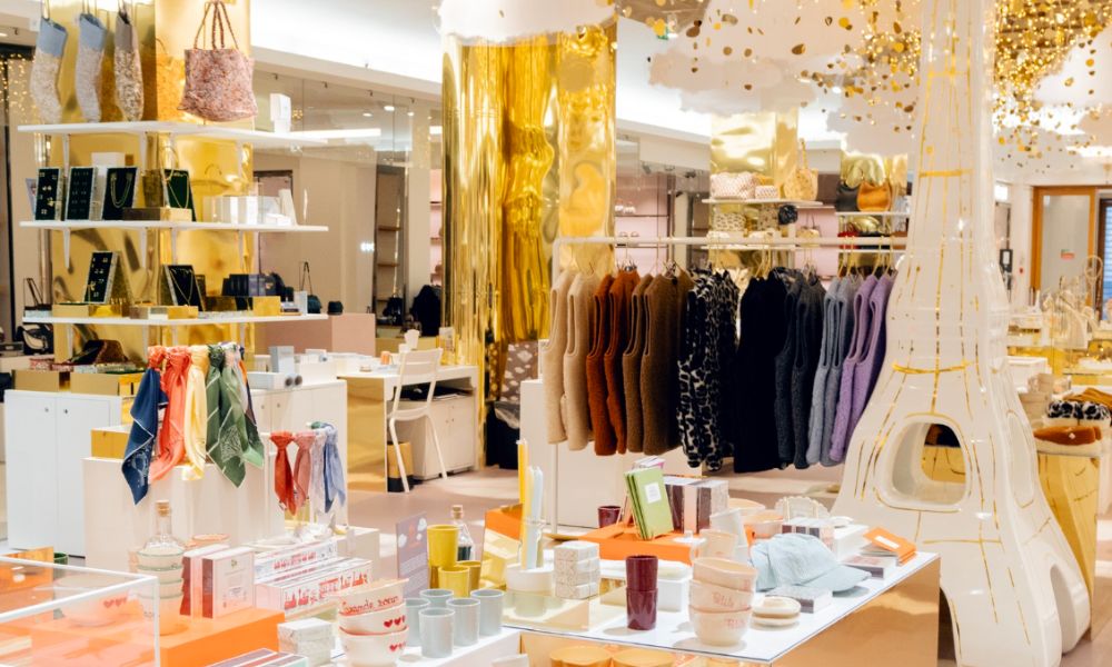 This is an image of a big department store with clothes hanging on a rack and lots of different things on shelves around.