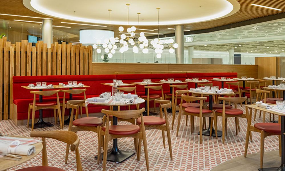 This is an image of a restaurant in the middle of CDG with some seating and cutlery set out.