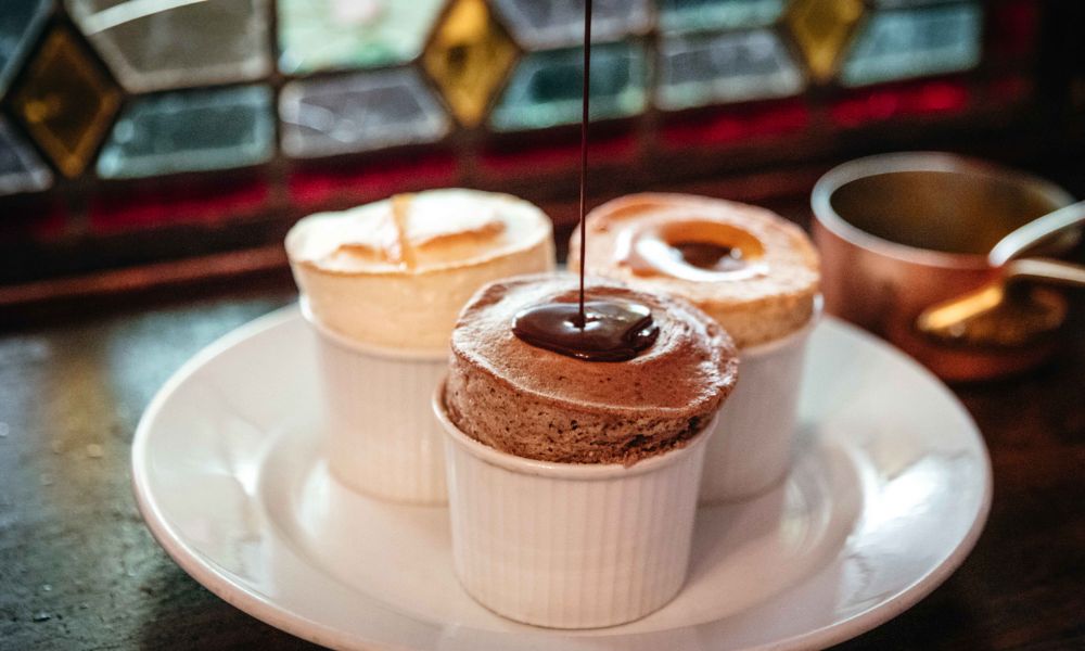 This is an image of three different risen souffles. One has an amazing chocolate sauce drizzle.
