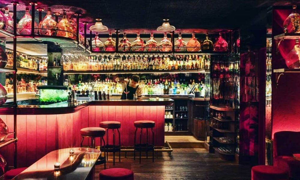 This is an image of a dark, low-lit bar with plenty of seats.