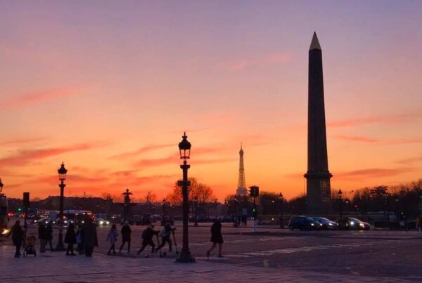 This is an image of the pillars in the Concorde Square in Paris with the backdrop of a burnt orange sunset.