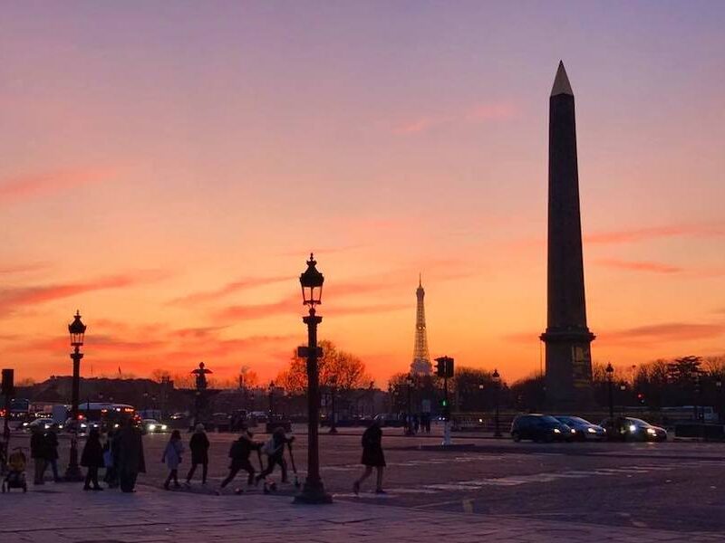 This is an image of the pillars in the Concorde Square in Paris with the backdrop of a burnt orange sunset.