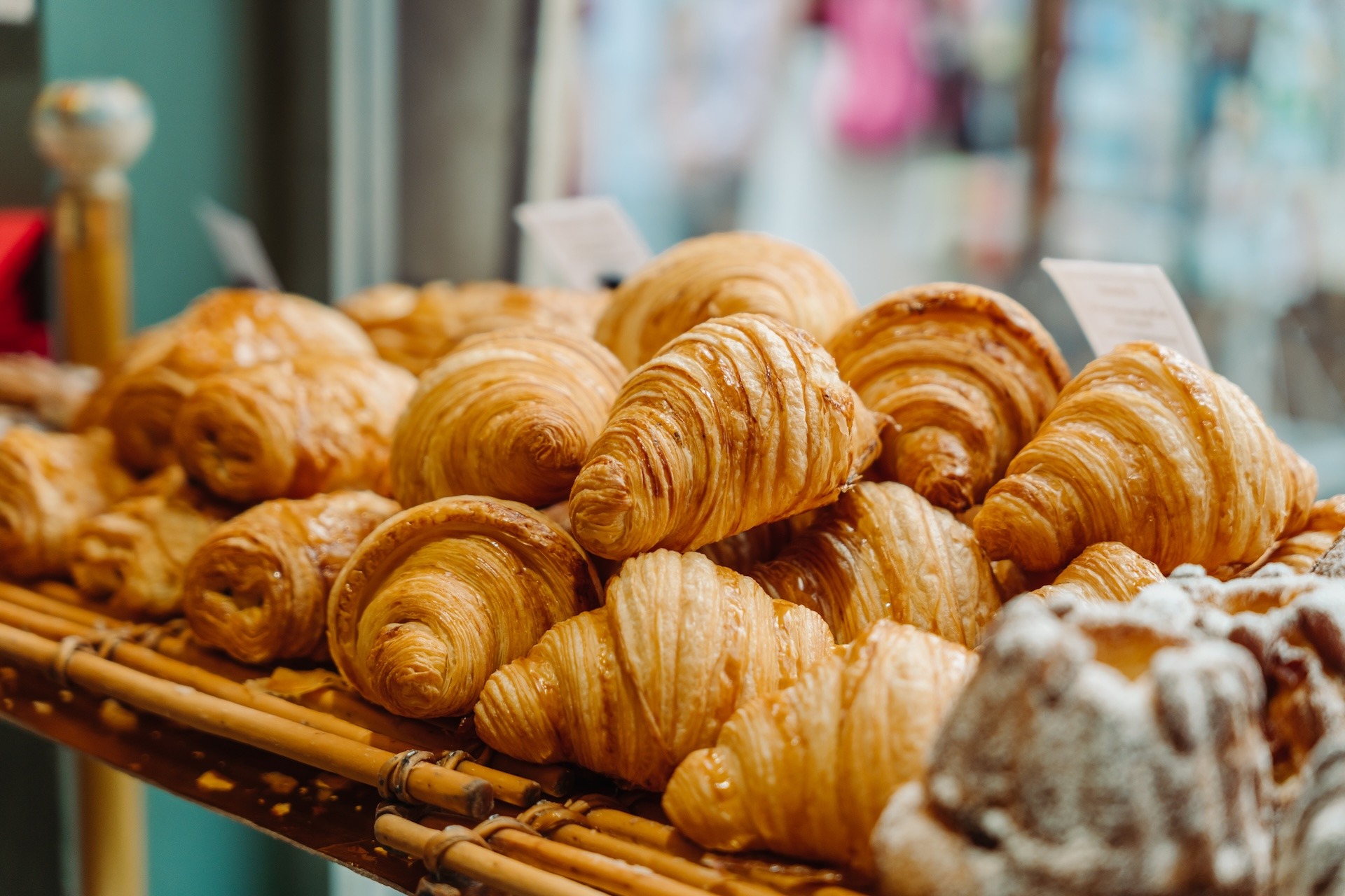 A window display of french pastries, including croissants.