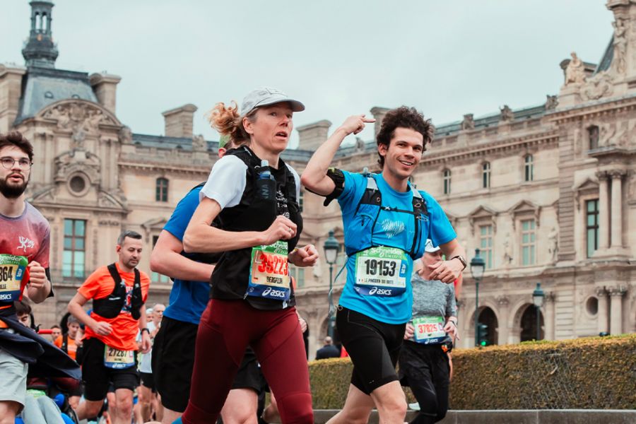 This is an image of people running the Paris Marathon in front of the Louvre building.
