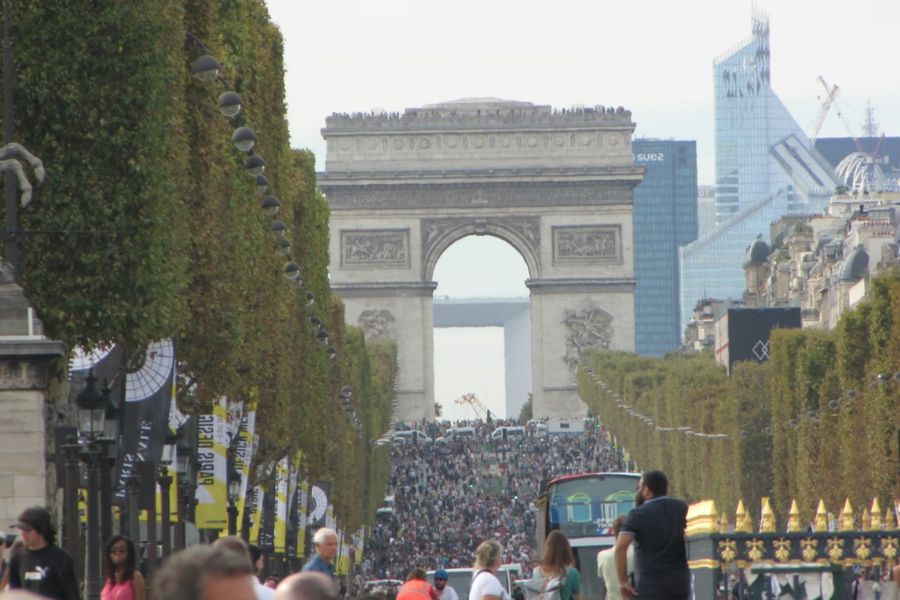 This is an image of runners running through the Champs Elysees, under the Arc De Triomphe.