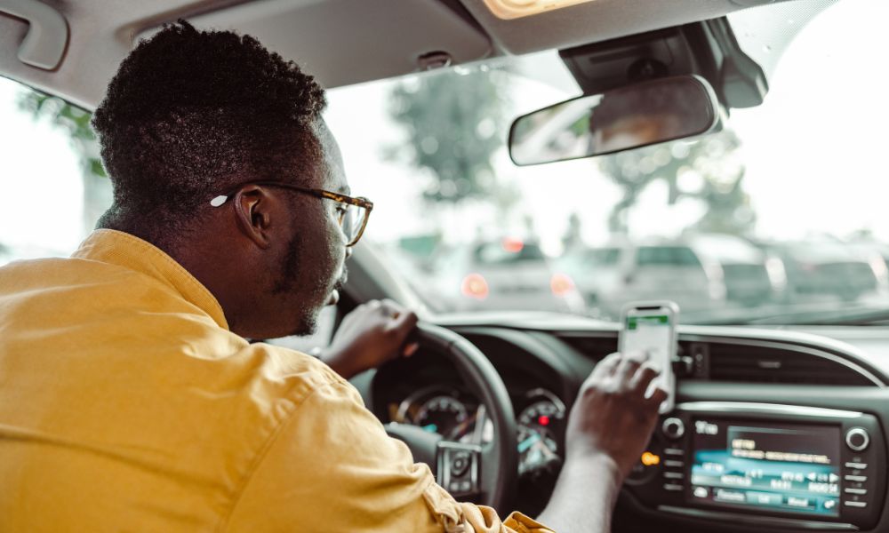 This is an image of a guy driving an Uber and looking on his GPS map for where to go next.
