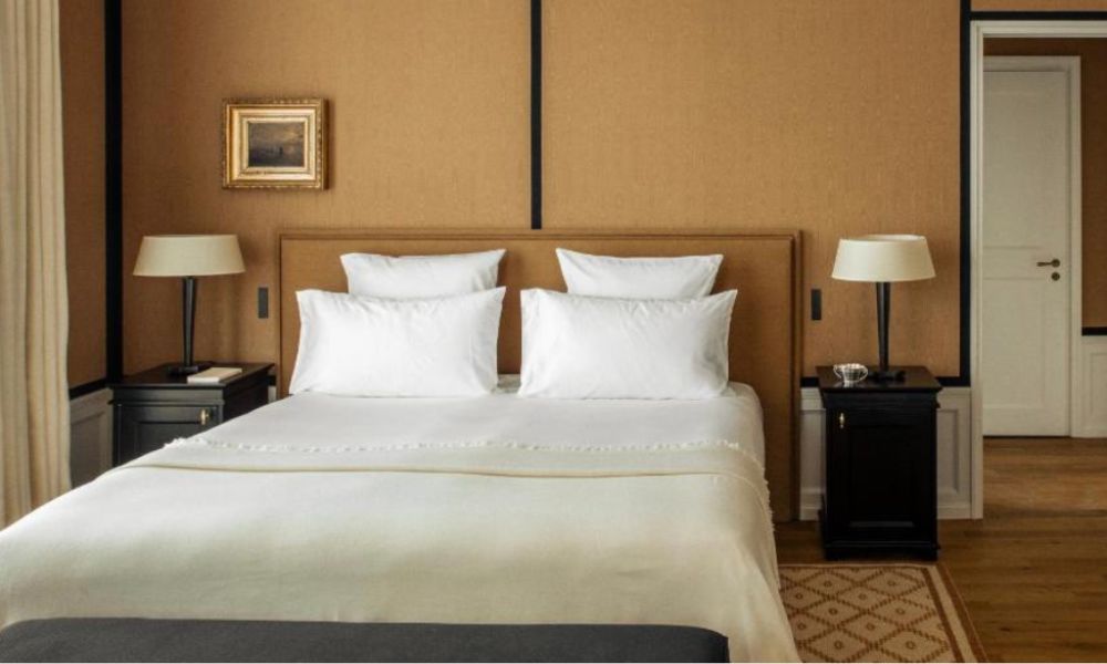 This is an image of a hotel room with a double bed, bedside tables, lamps and a lovely rug.