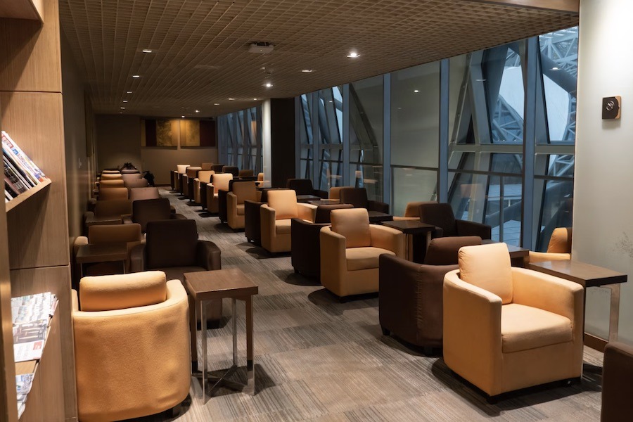 This is an image of an airport lounge with plenty of couches and sitting areas.