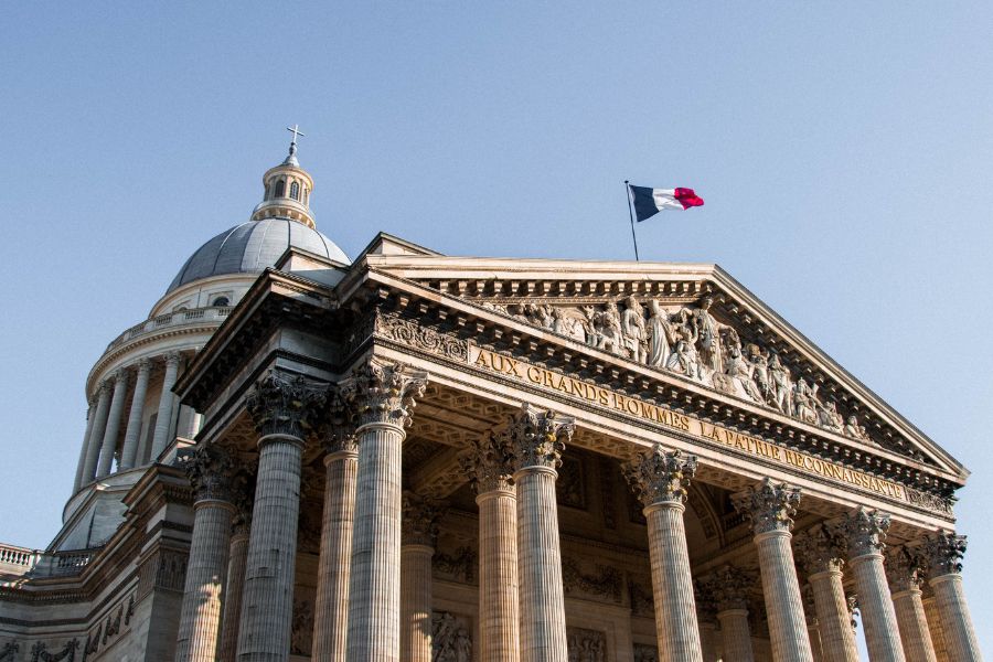 This is an image of the Pantheon in Paris with the French flag raised high above it.