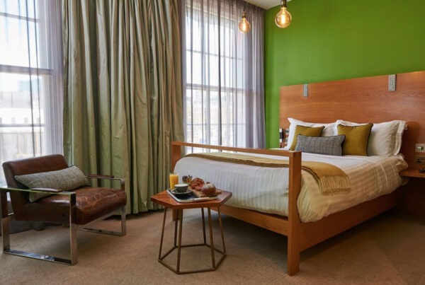 This is an image of a hostel bedroom with a double bed and simple furniture.