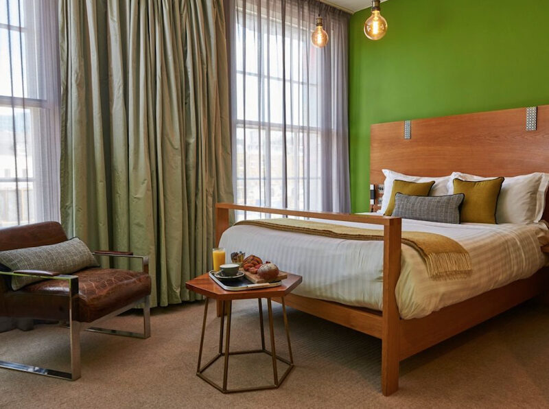 This is an image of a hostel bedroom with a double bed and simple furniture.