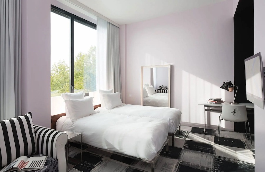 This is an image of a hotel bedroom with two beds next to each other and sleek modern furnishings throughout. One of our favourite Budget Friendly Hotels In Paris.