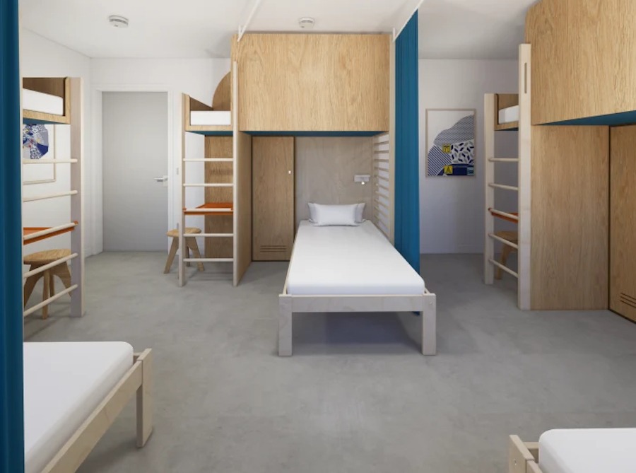 This is an image of a hostel bedroom with multiple white bunk beds.