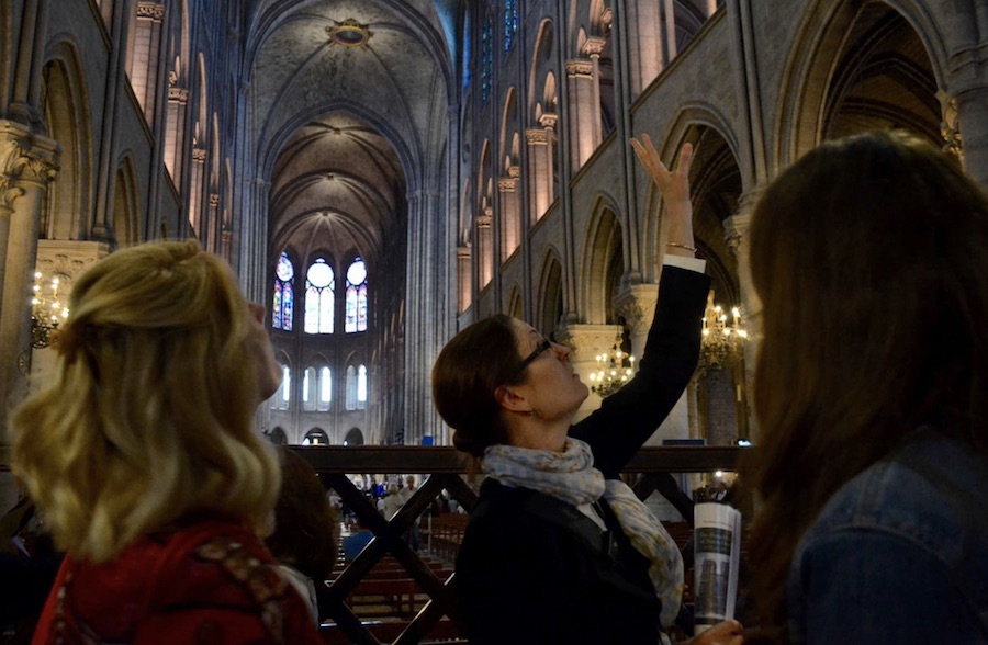 This is an image of a tour guide and her group inside the Saint-Chapelle Cathedral.