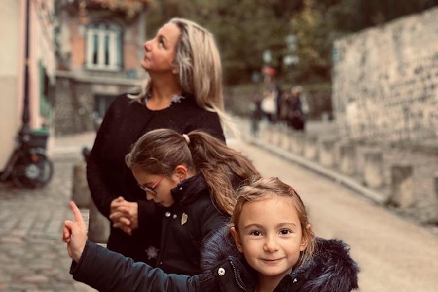 This is an image of two kids and their mother doing an escape game in Montmartre. One child is pointing up at something of interest.