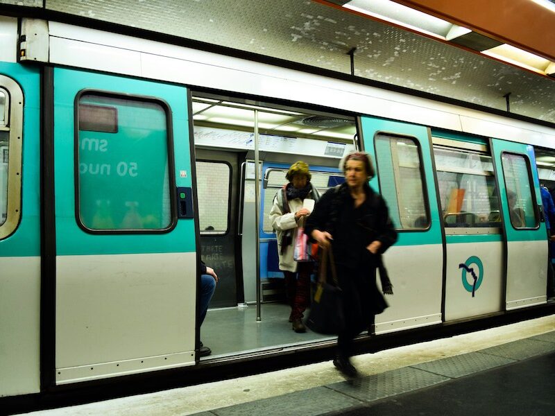 This is a picture of a woman stepping out of a Paris metro train.