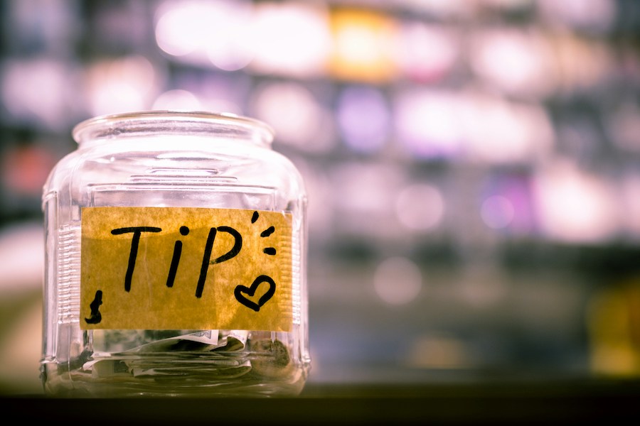 This is an image of a jar on a counter with a note labelled 'TIPS'.