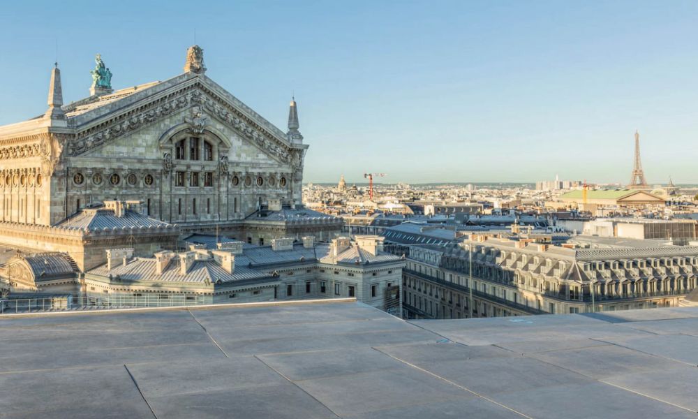 This is an image of a viewpoint with a beautiful old building right in front of it, and the Eiffel Tower in the distance.