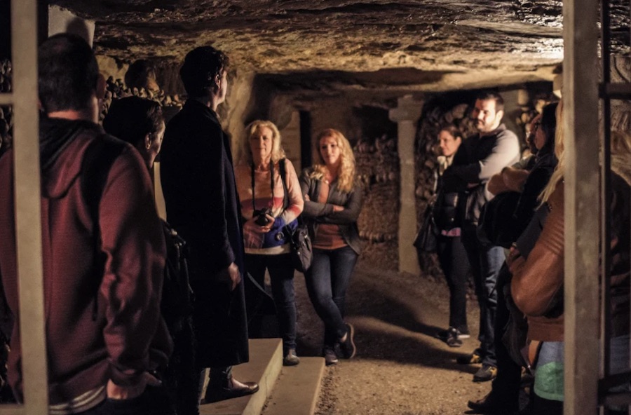 This is a picture of a tour group underground in the Catacombs.