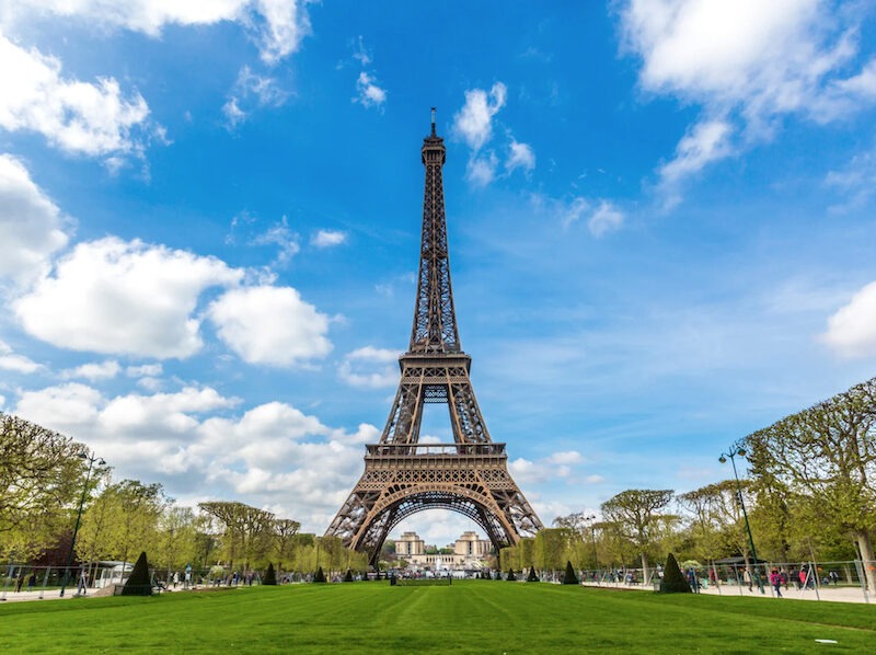 This is an image of the Eiffel Tower with a clear blue sky in the background and a few clouds.